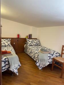 una camera con 2 letti e un pavimento in legno di La casa nel cortile a Castelbuono