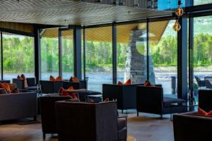 a lobby with couches and tables and windows at Sorrisniva Arctic Wilderness Lodge in Alta
