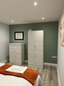 a bedroom with a bed and a cabinet and a mirror at Mary McGill’s in Ballycastle