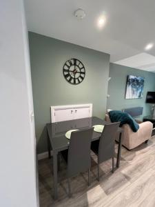 a living room with a table and a clock on the wall at Mary McGill’s in Ballycastle