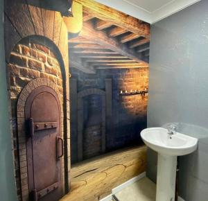 Un baño con lavabo y pared de ladrillo. en Hotel Of Wizardry, en Great Yarmouth 54 fotos más