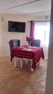 stół i dwa krzesła z wazonem kwiatów na nim w obiekcie Bustani Luxury Cottages w mieście Voi