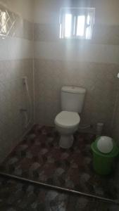 łazienka z toaletą i zielonym wiadrem w obiekcie Bustani Luxury Cottages w mieście Voi