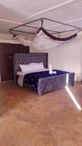 duże łóżko w pokoju z łóżkiem zawieszonym w obiekcie Bustani Luxury Cottages w mieście Voi