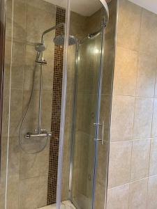 a shower with a glass door in a bathroom at Dunhill Townhouse in Goole