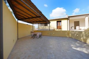 eine Terrasse mit Stühlen und einem Tisch in einem Haus in der Unterkunft Ma.Vi Casa Vacanze in Teulada