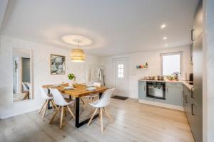 a kitchen and dining room with a wooden table and chairs at geräumiges familienfreundliches Ferienhaus 70 QM I Strandnah I Terrasse I 2 Schlafzimmer I Nähe Werbellinsee in Joachimsthal