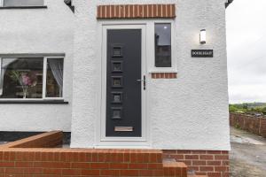 a black door on a white house with a window at H C Property - Doublegait in Barnard Castle