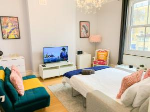 a living room with a bed and a tv at Enticing 2 Bed 2 Bath Flat in Hackney with garden in London