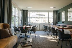 un ristorante con tavoli, sedie e un divano di ABION Villa Suites a Berlino