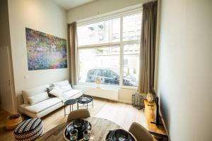 uma sala de estar com um sofá branco e uma grande janela em Beautiful 2-bedroom apartment 76m2 BSh-27 em Roterdã