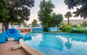 einen Pool mit einem Elefanten in der Mitte in der Unterkunft Hunguest Hotel Sun Resort in Herceg-Novi