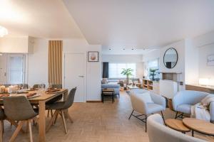 een eetkamer en een woonkamer met een tafel en stoelen bij Spacious house with garden for family and friends in Brugge