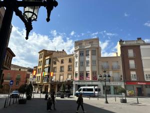 a group of people walking on a city street with buildings at Pensión Arnedo in Arnedo