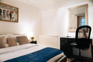 Curzon Residences في لندن: غرفة نوم بسرير ومكتب وكرسي