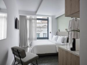 - une chambre blanche avec un lit et une fenêtre dans l'établissement RESIDENCE PATRAS, à Patras