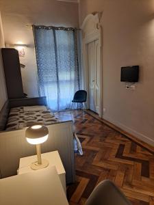 Camera piccola con letto e tavolo con lampada di Loca a Torino