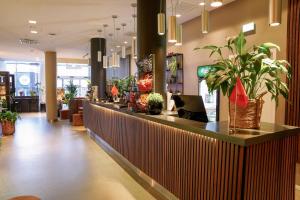 a lobby with a counter with potted plants on it at Comfort Hotel Winn in Umeå