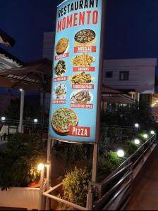 Una señal para un restaurante con pizzas. en Vila Spiro, en Ksamil