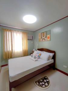 a bedroom with a large white bed with a window at Palawan Paradise Condotel 2B in Puerto Princesa City