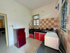 eine Küche mit roten Schränken und einem roten Kühlschrank in der Unterkunft Lovely 2bhk near Hitech City in Kondapur