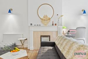 伦敦Parea Living - South Kensington, Elegant 1-Bedroom Flat, WFH Desk的带沙发和壁炉的客厅