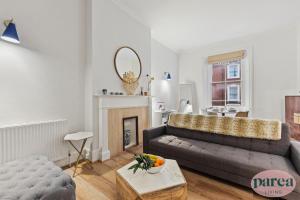 伦敦Parea Living - South Kensington, Elegant 1-Bedroom Flat, WFH Desk的带沙发和壁炉的客厅 更多32张照片