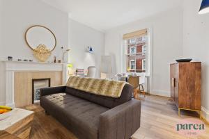 伦敦Parea Living - South Kensington, Elegant 1-Bedroom Flat, WFH Desk的带沙发和壁炉的客厅