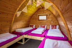 two beds in a room in a log cabin at Podumna Glamping Village in Portumna