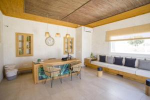 a living room with a couch and a table and chairs at Jenny's Summer Houses in Platis Yialos Mykonos