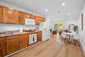a kitchen with wooden cabinets and a dining room with a table at Spacious 2 BR @Sailboat Bend in Fort Lauderdale