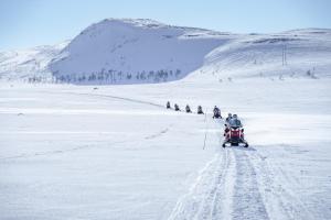 a group of people riding on motorcycles in the snow at Sorrisniva Arctic Wilderness Lodge in Alta