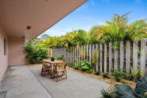 un patio con mesa y sillas frente a una valla en Spacious 2 BR @Sailboat Bend, en Fort Lauderdale