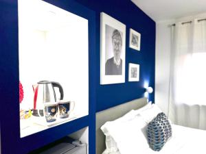 een slaapkamer met een blauwe muur met een bed en een plank bij Room Center Sorrento Baby in Sorrento