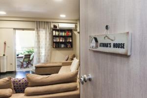 a living room with a couch and a house sign on the door at Stylish Athinas House in Kallithea in Athens