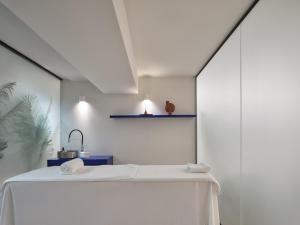 a white room with a table and a shelf at The Newel Acropolis in Athens