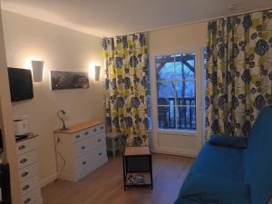 - un salon avec un canapé bleu et une fenêtre dans l'établissement Corrèze rive Dordogne, à Argentat