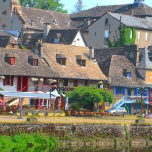 un gruppo di edifici con tavoli e sedie di Corrèze rive Dordogne ad Argentat