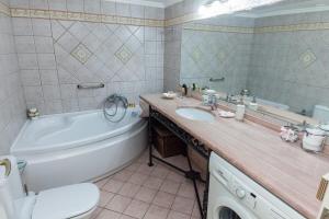 uma casa de banho com uma banheira, um WC e um lavatório. em Deluxe 2 Bedroom apt in Petroupoli em Atenas