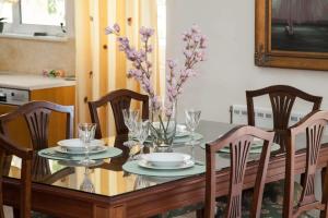 uma mesa de jantar com um vaso de flores roxas em Deluxe 2 Bedroom apt in Petroupoli em Atenas