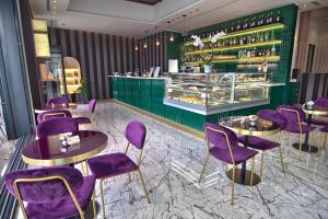a restaurant with purple chairs and a green counter at Gigi Suites&Apartments in Stresa