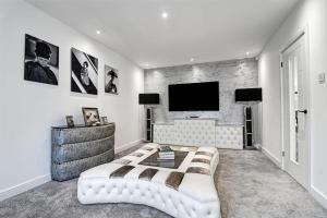 a bedroom with a couch and a flat screen tv at Haus of Hale in Ashley