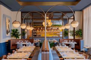 a dining room with tables and chandeliers at The Godfrey Detroit, Curio Collection By Hilton in Detroit