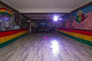 an empty bowling alley with colorful walls and wooden floors at The Whispering Inn Resort and Bar (An Exotic Vintage Beauty ) in Manāli