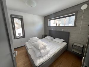 1 dormitorio con 1 cama con sábanas y almohadas blancas en Funäsdalshöjden Funäsdalen en Funäsdalen