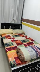 a bed with a colorful quilt on top of it at Sahara Hostel and Private rooms in Dubai