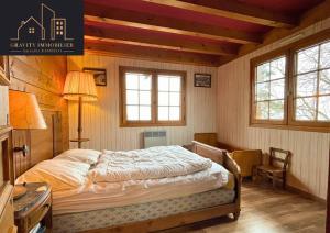 1 dormitorio con 1 cama, escritorio y ventanas en Chalet 4 pièces + Mezzanine , Les Carroz, en Les Carroz d'Araches