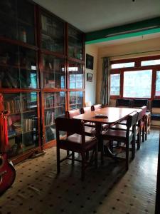 - une salle à manger avec une table et des chaises en bois dans l'établissement Sanu House, à Pātan