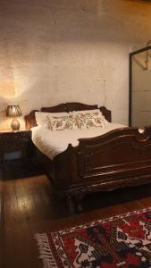Ce lit se trouve dans une chambre avec une lampe et une table. dans l'établissement Avangart Hotel, à Avanos