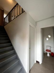 a hallway with a staircase and a toilet in a house at Le coin cosy 38 m2 in Orchies